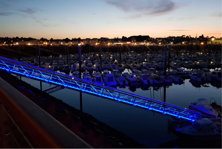 Mise en lumière bleue d'une passerelle dans un espace urbain